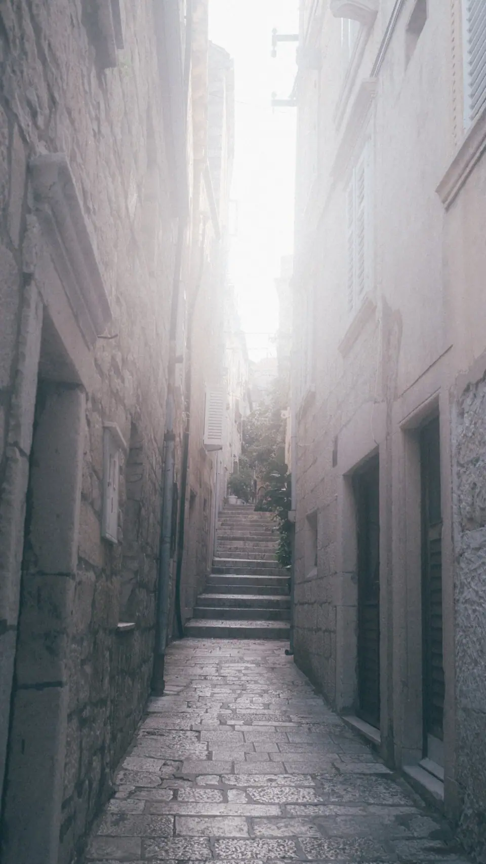 Soft flare across receding stone steps in a vertical view.