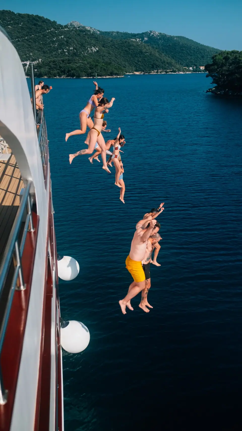Bodies hang vertically above deep blue water.