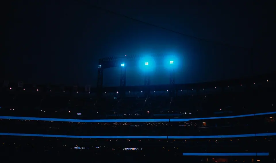 Three blue lights and thin horizontal bands at night.