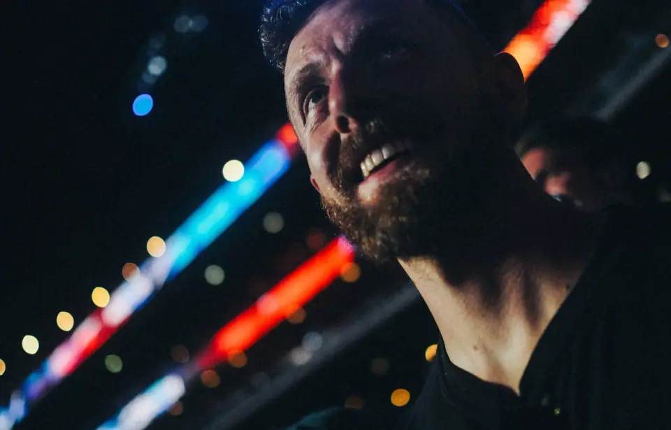 A close portrait with diagonal colored lights.