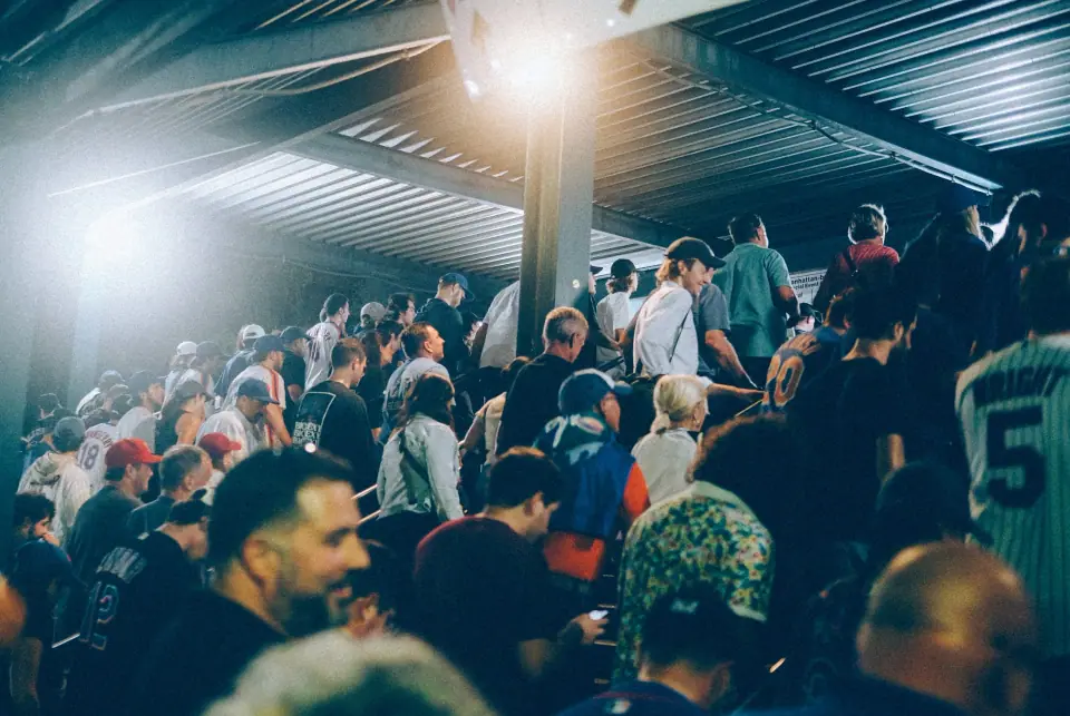Overlapping people beneath bright overhead lights.