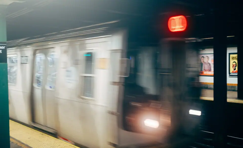 A moving train forms a streak of pale light with a red accent.