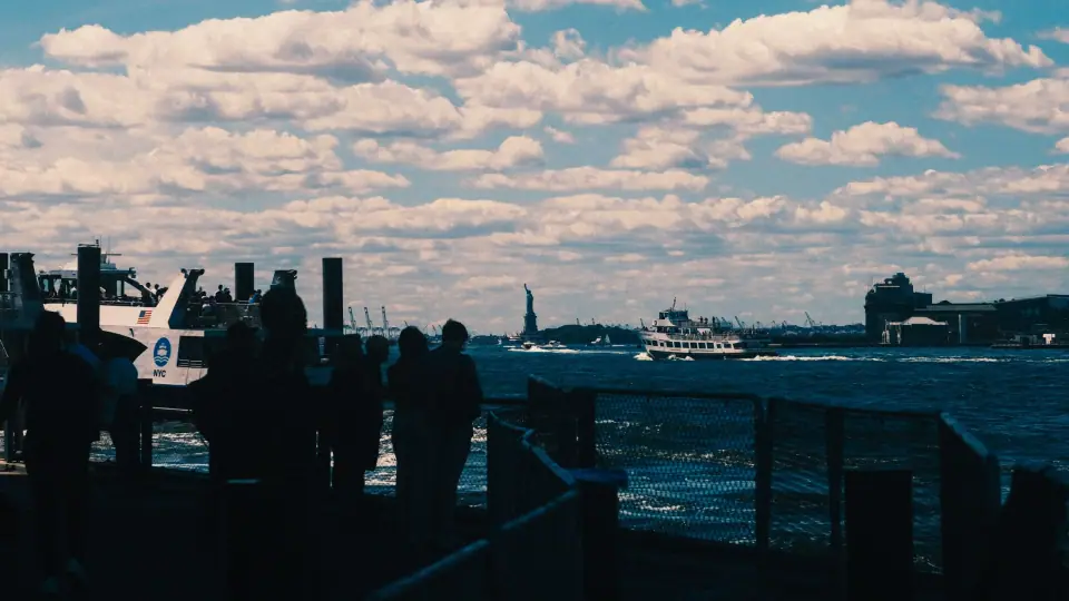 Dark waterfront silhouettes beneath a broad, cloud-filled sky.