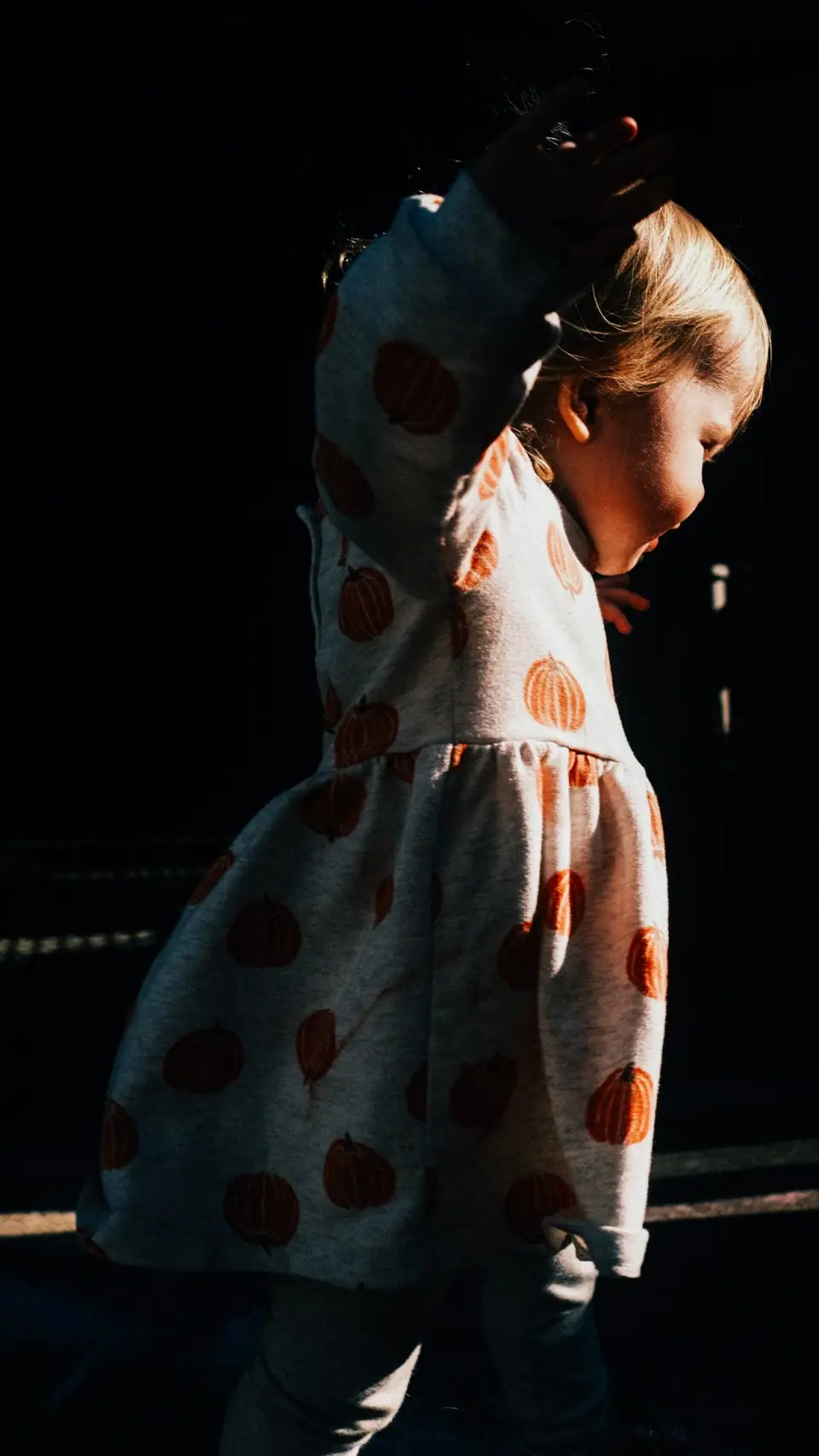 Hard side light illuminates a figure against a black background.