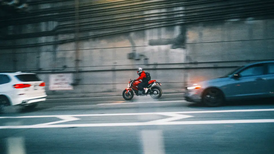 A red rider remains sharp amid the horizontal blur of traffic.