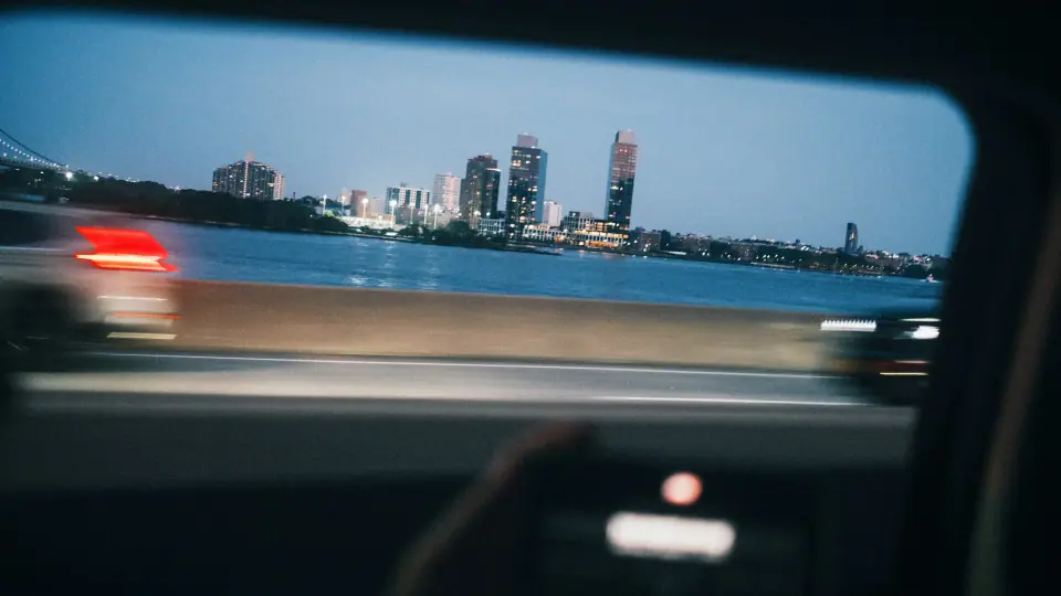 A car window frames passing lights.