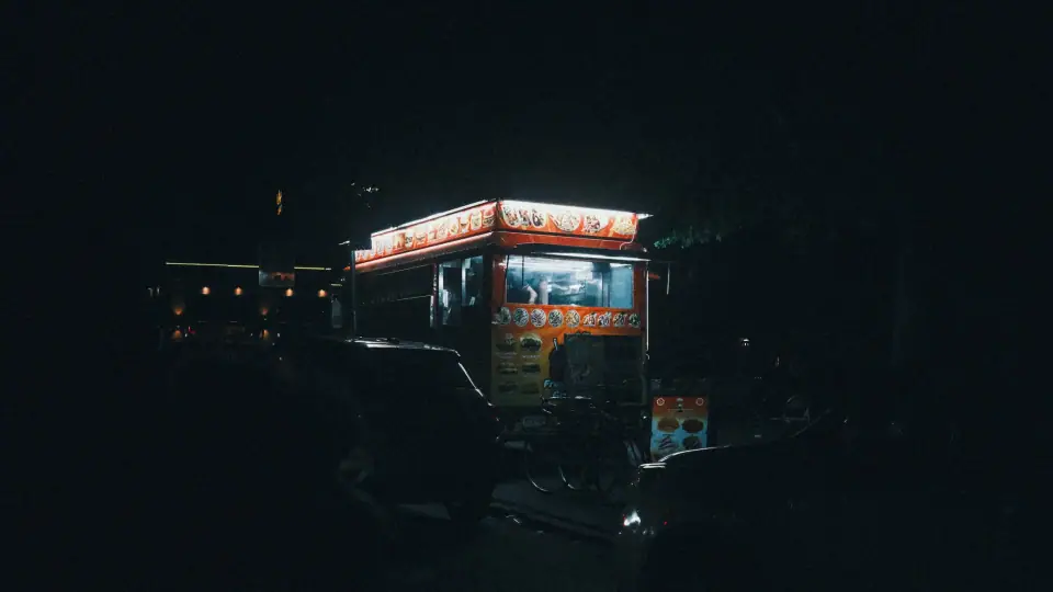 An illuminated cart stands in surrounding darkness.