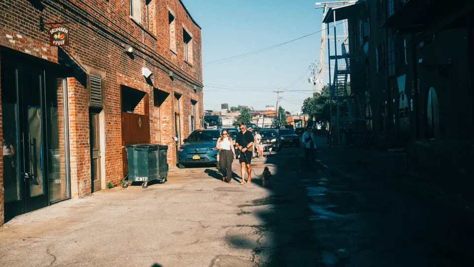 A sharp boundary between sun and shade divides a small street scene.