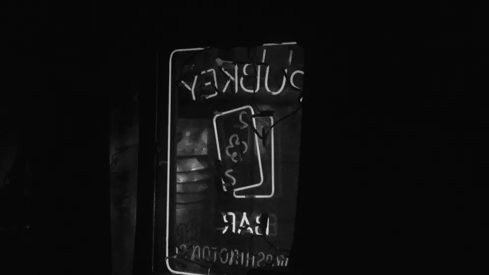 Reversed lettering beside a dark mirror at night.