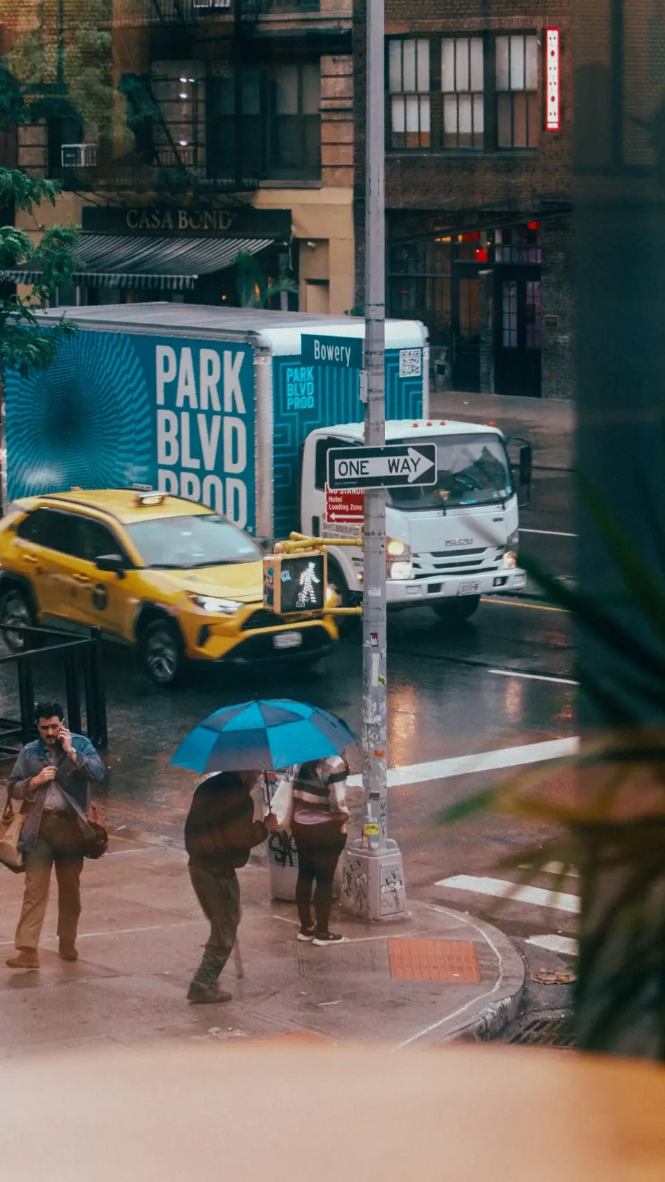 Pedestrians, vehicles, and street graphics overlap in a view from above.