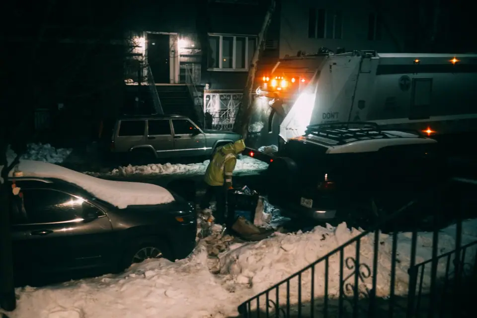 Orange work lights along a dark, snowy street.