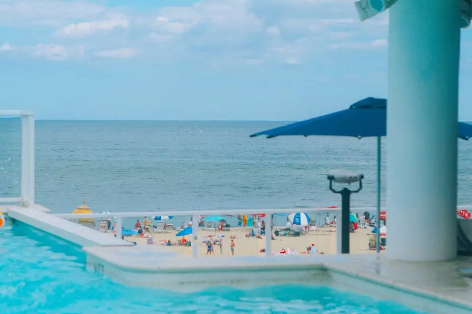Pool edges, columns, and the horizon form pastel geometric shapes.