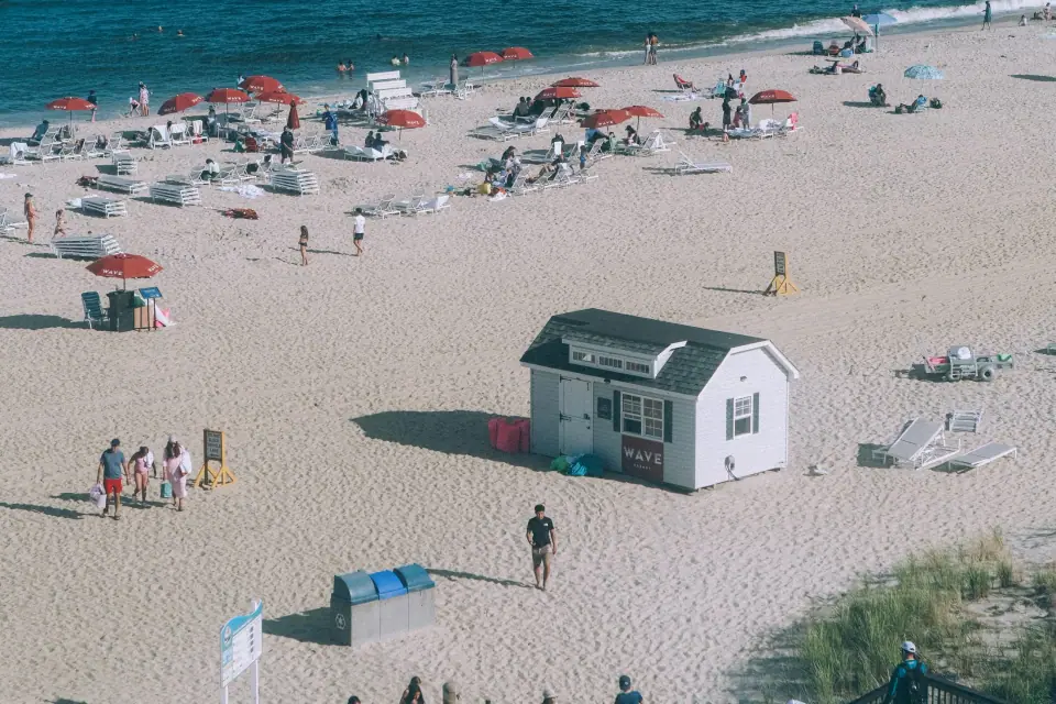 An elevated beach view with tiny figures and an isolated hut.